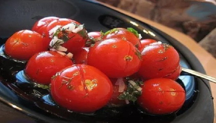 Малосольные помидоры с чесноком и зеленью в кастрюле